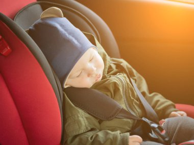 Modern araba koltuğunda uyuyan kafkas sevimli erkek bebek kapatın. Yolda güvenlik içinde seyahat eden çocuk. Küçük çocuklar ile bir araçta sabitlenmiş emniyet kemerleri seyahat etmek için güvenli bir yol. Bebek ile Trip.