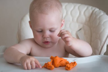 Çocukların yaratıcılığı. Bebek kilden heykel yapmaya çalışıyor. Masada plasticine sevimli küçük çocuk kalıp