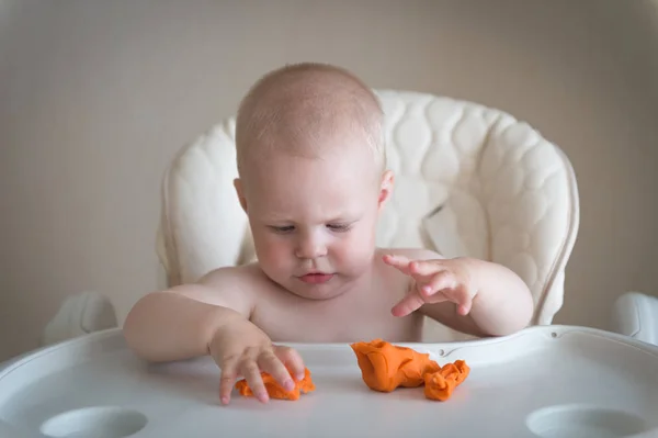 Criatividade infantil. o bebê está tentando esculpir de barro. Molde menino bonito de plasticina na mesa — Fotografia de Stock