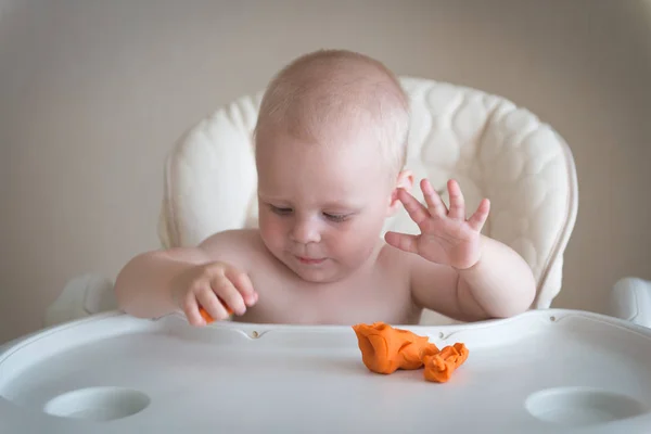 La créativité des enfants. le bébé essaie de sculpter à partir d'argile. Mignon petit garçon moule de plasticine sur la table — Photo