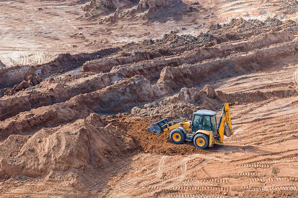 轮式装载机挖掘机在施工现场作业。土方工程中沙坑的轮式装载机 — 图库照片