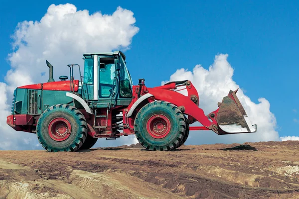 红色挖掘机在建筑工地上对抗蓝天 土方工程中沙坑的轮式装载机 — 图库照片