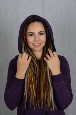 Şık, güzel, beyaz takım elbiseli, saçı rastalı bir kızın stüdyo prömiyeri. Moda ve güzellik konsepti