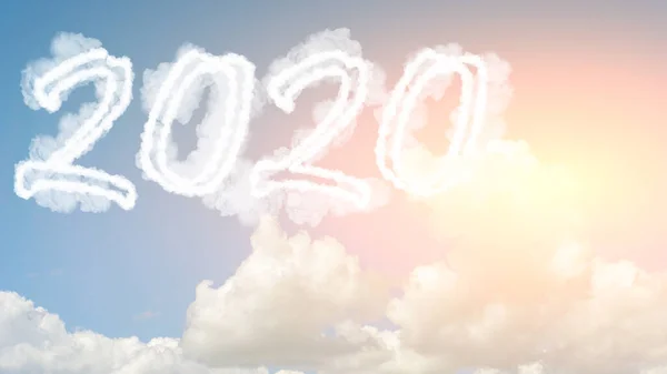 Nube de cielo soleado año 2020. Feliz año nuevo concepto. Números 2020 símbolo inscripción en el fondo del cielo azul de humo blanco de las nubes con sol brillante — Foto de Stock