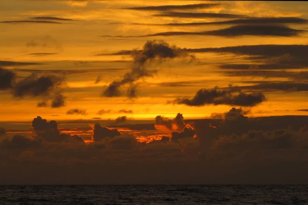 Красивый красный закат над океаном. Яркий закат с большим желтым солнцем под поверхностью моря. закатный морской пейзаж — стоковое фото