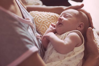 Yeni doğmuş bir kız annesinin kollarında huzur içinde uyuyor. sağlıklı bir çocuk ve mutlu bir annelik..