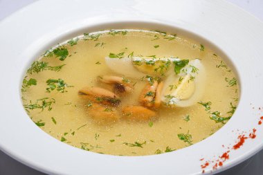 Çorba köfte, yumurta ve yeşillik ile. Beyaz arka plan. Sarı.