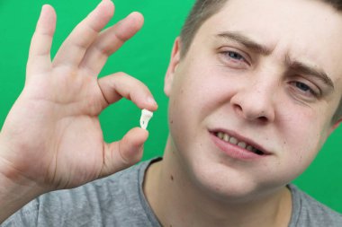 Bir yirmilik diş çıkardıktan sonra bir adam. Sekizinci dişleri çıkarmak işlemi