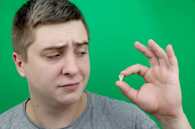 Bir yirmilik diş çıkardıktan sonra bir adam. Sekizinci dişleri çıkarmak işlemi