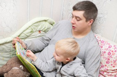 Baba oğlu masal okur.