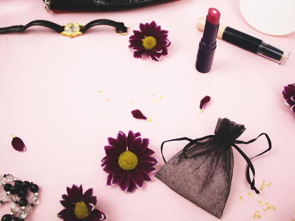 Cosmetics on the table at the woman. Cosmetic bag, cosmetic and hygiene products. Pink background for text