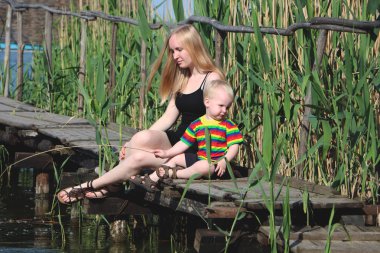 Nehrin yanında köprüde bir genç anne ve oğlu dinleniyor. Yaşam tarzı kavramı