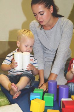 Eğitimci anaokulunda çocuk ile ilgilidir. Yaratıcılık ve çocuk gelişimi