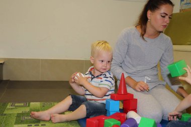 Eğitimci anaokulunda çocuk ile ilgilidir. Yaratıcılık ve çocuk gelişimi