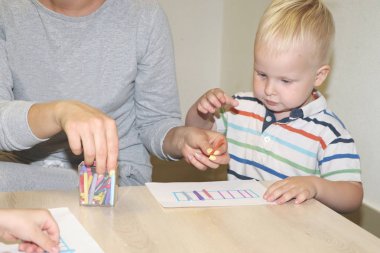 Eğitimci anaokulunda çocuk ile ilgilidir. Yaratıcılık ve çocuk gelişimi