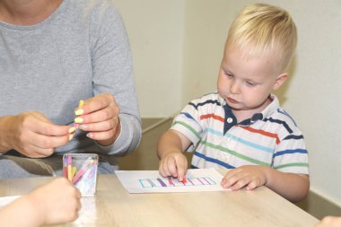 Eğitimci anaokulunda çocuk ile ilgilidir. Yaratıcılık ve çocuk gelişimi