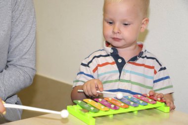 Eğitimci anaokulunda çocuk ile ilgilidir. Yaratıcılık ve çocuk gelişimi