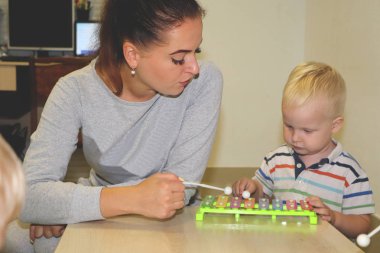 Eğitimci anaokulunda çocuk ile ilgilidir. Yaratıcılık ve çocuk gelişimi