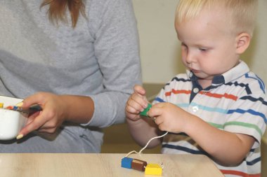 Eğitimci anaokulunda çocuk ile ilgilidir. Yaratıcılık ve çocuk gelişimi