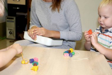 Eğitimci anaokulunda çocuk ile ilgilidir. Yaratıcılık ve çocuk gelişimi