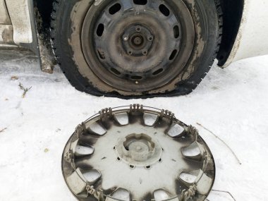 Delikli ve düz lastik yolda. Tekerlek bir jack ile sürücü tarafından yerine