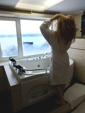 Sıcak bir küvet içinde güzel bir kadın. Otel, panoramik banyo penceresinden jakuzide