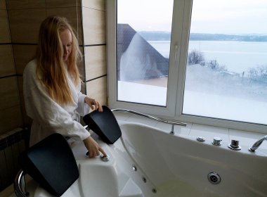 Sıcak bir küvet içinde güzel bir kadın. Otel, panoramik banyo penceresinden jakuzide