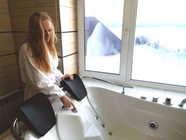 Sıcak bir küvet içinde güzel bir kadın. Otel, panoramik banyo penceresinden jakuzide