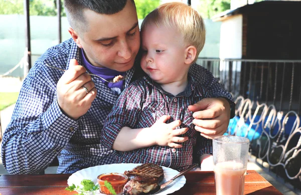 Dad feeds the child in a cafe