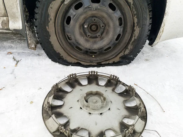 Delikli ve düz lastik yolda. Tekerlek bir jack ile sürücü tarafından yerine