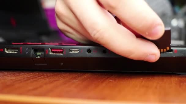 Ordinateur portable, retiré la coque arrière, les puces visibles et la main d'un maître. Le concept de réparation des ordinateurs portables et des ordinateurs. Ordinateurs portables poussiéreux 