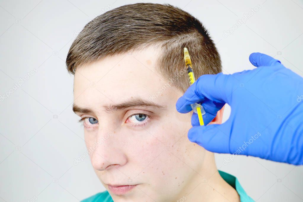 Hair mesotherapy or hair transplant: beautician doctor makes injections in the mans head for hair growth or to prevent baldness