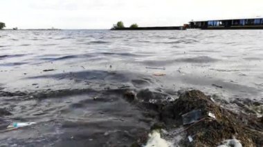 Kumlu sahilde plastik şişeler ve bardaklar. Zllichny çöpyüzer kirli su. Sahilde beyaz köpük