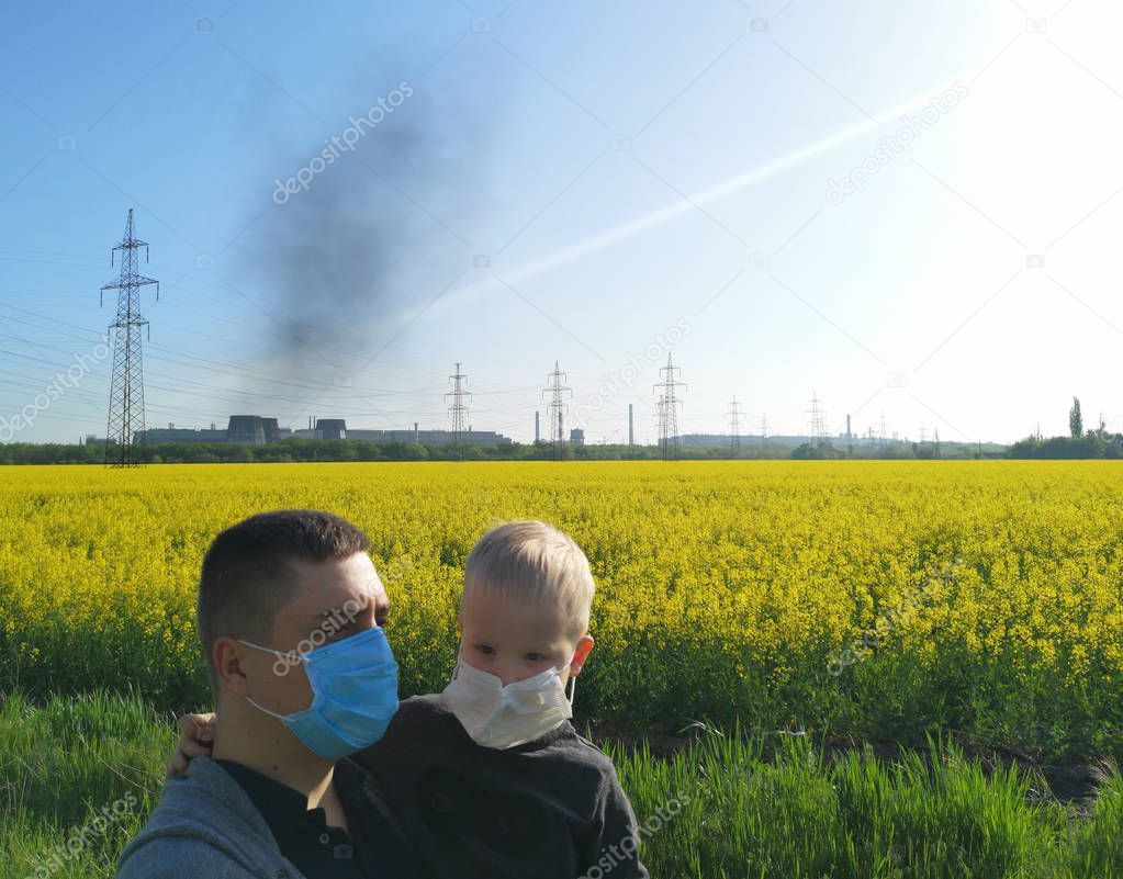 A man with a child in his hands in medical masks on the background of the plant. The concept of environmental pollution, ecology