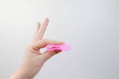 Bir kadın elinde pembe bir arka plan üzerinde bir adet fincan tutar. Kadın sağlığı, hijyen, alternatif ped ve tampon kavramı