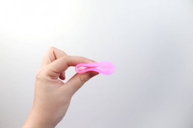 Bir kadın elinde pembe bir arka plan üzerinde bir adet fincan tutar. Kadın sağlığı, hijyen, alternatif ped ve tampon kavramı