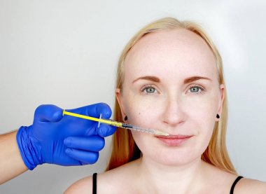 Doktor güzellik kontur plastik dudaklar yürütmektedir: dudaklara bir enjeksiyon, dudak büyütme. Hyaluronik asit enjeksiyon dolgu maddeleri