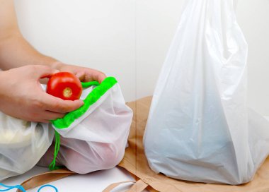 Sebze ve meyve ile alışveriş için plastik torba ve eko doğal yeniden tote çanta. Yeniden kullanılabilir şeyler lehine bilinçli bir seçim kavramı ve tek kullanımlık plastik malların reddi. Çevre koruma, felsefe sıfır batı