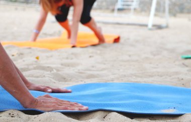 Sahilde yoga. Lotus pozisyonunda kız bacaklarını kapatın. İmza için bulanık arka plan. Spor yapmak, pilates yapmak, dışarıda esnemek