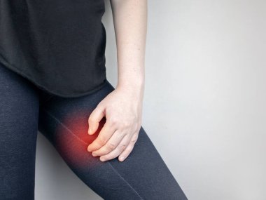 A woman suffers from pain in the inner thigh. The concept of treating a hip joint for trauma, myositis, impaired nerve endingsor osteoarthritis. clipart
