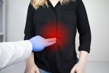 Bir kadın onun karnına tutunuyor. Karın boşluğunda bir ağrı var. Mide hastalıkları ve sindirim sistemi kavramı. Bir gastroenterolog hastayı muayene eder..