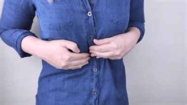 Bir kadın onun karnına tutunuyor. Karın boşluğunda bir ağrı var. Mide ve sindirim sistemi hastalıkları kavramı