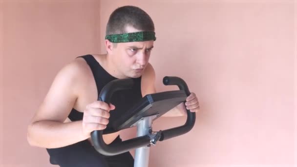 Vidám Kövér Ember Vicces Melegítőben Egy Álló Kerékpárral Koncepció Problémák — Stock videók