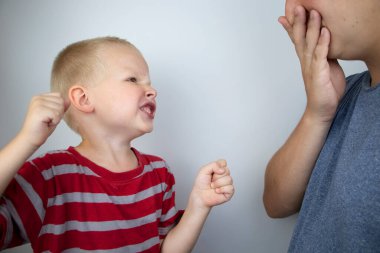 Çocuk yumruklarını sallıyor ve babasına bağırıyor. Çocuk saldırganlığı, aile içi çatışmalar, üç ila dört yıllık bir kriz. Çocukların öfkesi ve babalarının kısıtlaması..