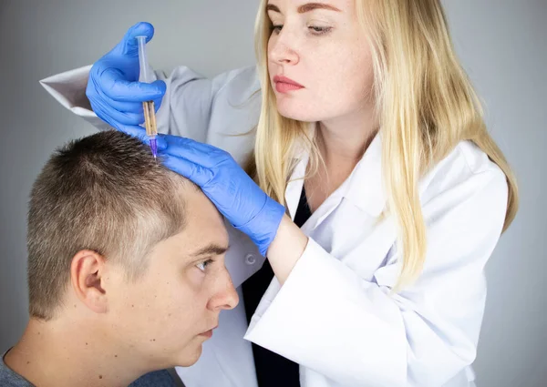 The doctor trichologist conducts mesotherapy or plasma therapy. Treatment of alopecia. Hair loss, alopecia, pruritus, burning head or seborrhea