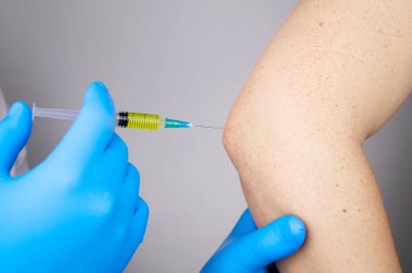 Bir ortopedik cerrah dirseğinden iğne yapar. Hyaluronik asite dayanan hormonal ilaçlarla ya da ilaçlarla osteoartrit tedavisi. Eklem kıkırdağına zarar veren hastalıklara yardım