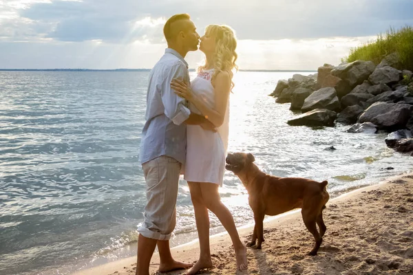 A couple of lovers lies on the beach next to their dog. Camping with pets. Love concept for each other and animals