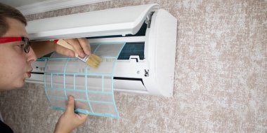 Klimayı tozdan, küften ve çamurdan temizliyorum. Bir klima bakım işçisi kirlilik seviyesini ölçer, radyatörü temizler ve çürüklerdeki kirliliği temizler..