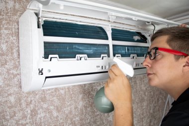 Klimayı tozdan, küften ve çamurdan temizliyorum. Bir klima bakım işçisi kirlilik seviyesini ölçer, radyatörü temizler ve çürüklerdeki kirliliği temizler..