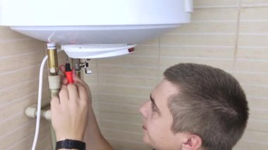 Bir çilingir çalışmayan bir kazanı tamir eder. İşçi elektronik aletleri kontrol edecek ve ayarlanabilir bir anahtarla borunun vidasını sökecek. Teknik yardım kavramı